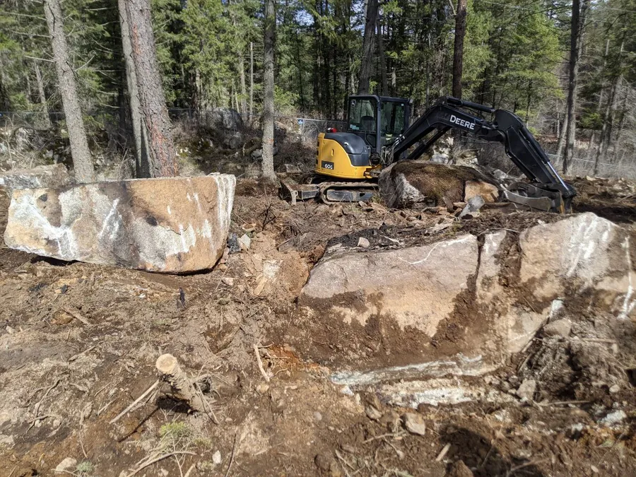 Excavator working through rocks on a job site