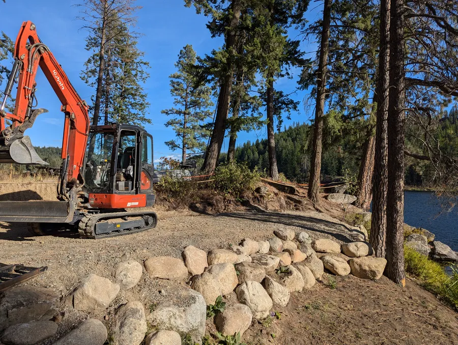 Excavator clearing brush and overgrowth on a property